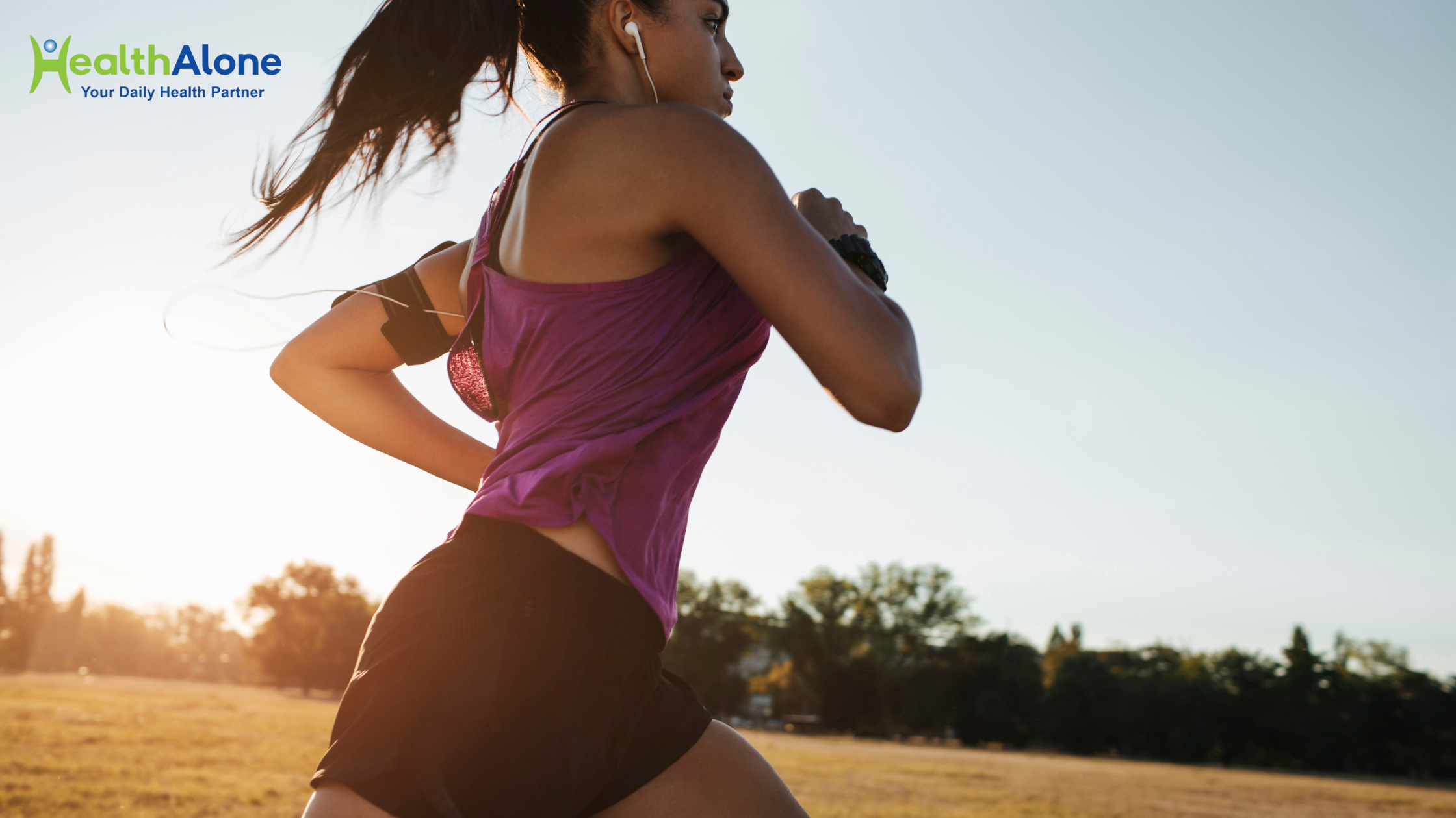 Woman running outdoors at sunrise with the HealthAlone logo in the top-left corner.
